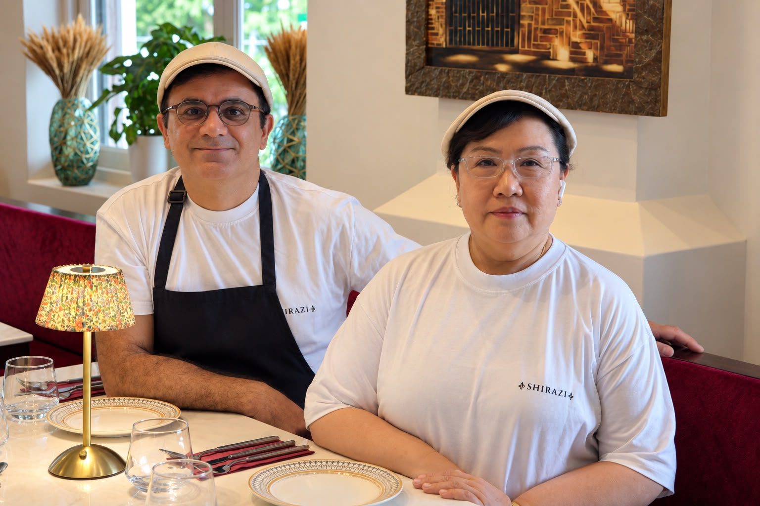 Chef Mohammad Hosseini and Chef Ying at a table at Shirazi, in Shirazi whites