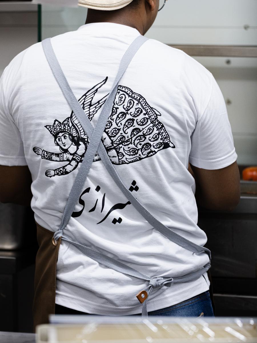 The chef at work, Shirazi calligraphy across his back