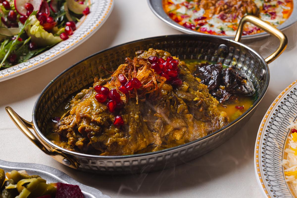 Ghormeh sabzi finished with crisped onion and pomegranate