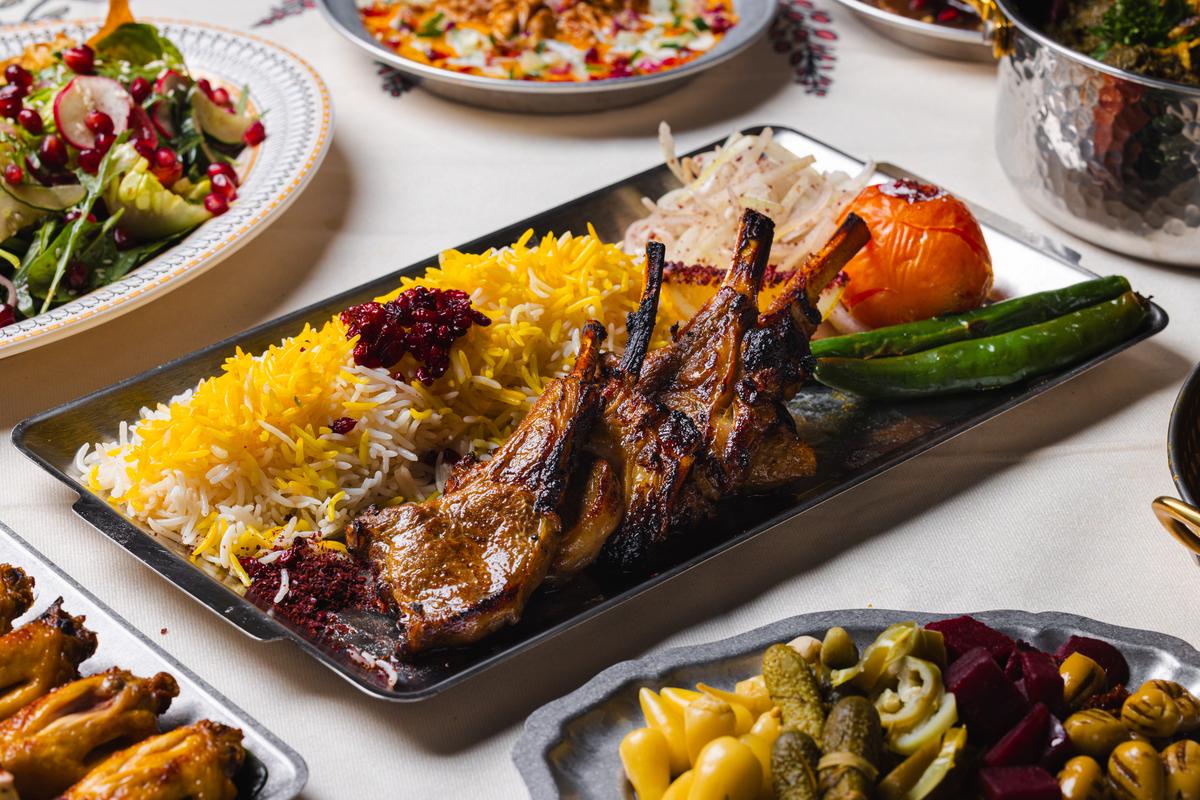 Charcoal-grilled lamb chops over saffron rice with grilled tomato