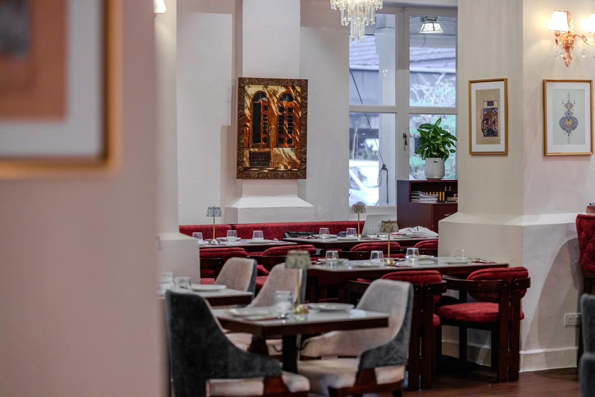 The dining room in soft daylight, tables set in rose and burgundy