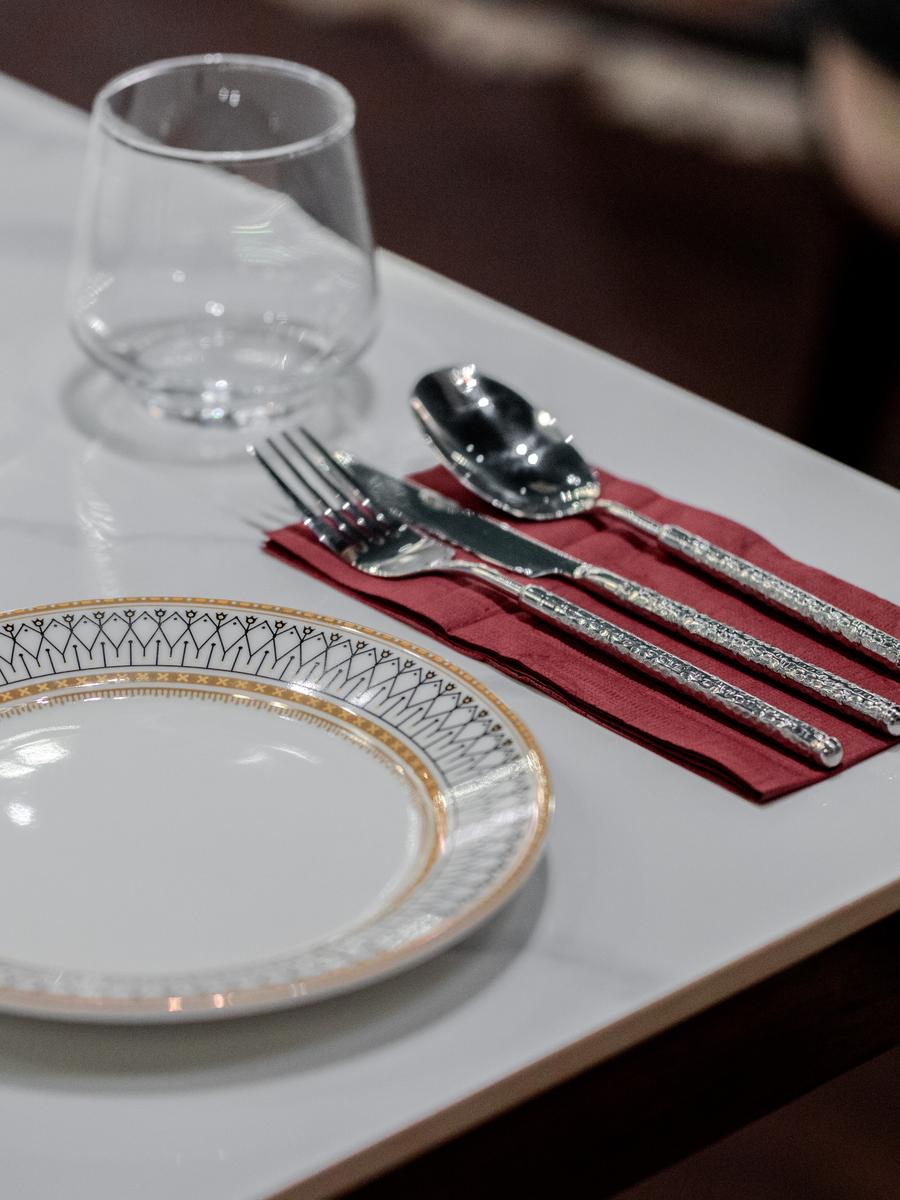 A single place setting: gold-rimmed porcelain on marble